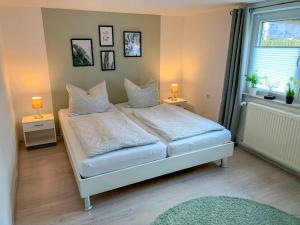 a bedroom with a bed with pillows and a window at Holiday Home Vosshörn by Interhome in Westerschoo