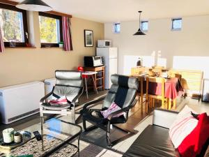 ein Wohnzimmer mit 2 Stühlen und einem Tisch in der Unterkunft Holiday Home Au bord du Lac-1 by Interhome in Bütgenbach