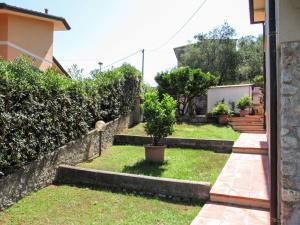 a backyard with a retaining wall and a yard with trees at Apartment Cristina-1 by Interhome in Santa Lucia