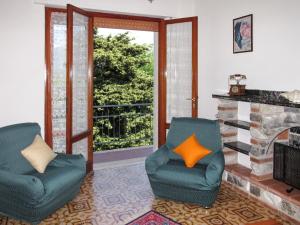 a living room with two chairs and a fireplace at Apartment Cristina-1 by Interhome in Santa Lucia