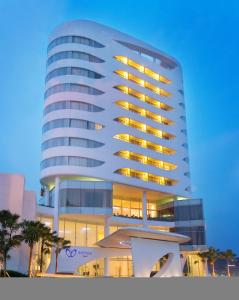 a tall white building with its lights on at Sensa Hotel Bandung in Bandung