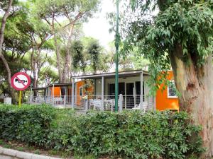 una casa arancione con un cartello davanti di Holiday Home Maxi Caravan Ischia by Interhome a Baia Domizia