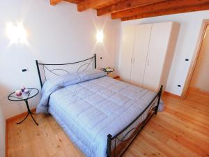 a bedroom with a bed with a blue comforter at Holiday Home Albergo Diffuso - Cjasa Ressa by Interhome in Barcis