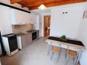 una cucina con tavolo e sedie in una stanza di Holiday Home Albergo Diffuso - Cjasa Ressa by Interhome a Barcis