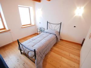 una camera con un letto in una stanza con pavimenti in legno di Holiday Home Albergo Diffuso - Cjasa Ressa by Interhome a Barcis
