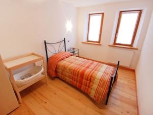 a small bedroom with a bed and a wooden floor at Holiday Home Albergo Diffuso - Cjasa Marisa by Interhome in Barcis