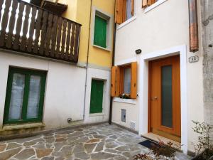 un edificio con puertas verdes y balcón en Holiday Home Albergo Diffuso - Cjasa Marisa by Interhome en Barcis