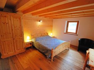 ein Schlafzimmer mit einem Bett in einem Zimmer mit Holzdecken in der Unterkunft Apartment Albergo Diffuso - Cjasa de Barce-2 by Interhome in Barcis