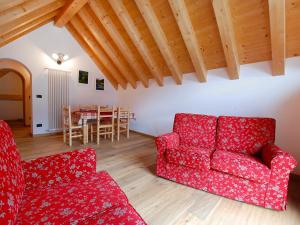 sala de estar con sofá rojo y mesa en Apartment Albergo Diffuso - Cjasa de Barce-2 by Interhome, en Barcis