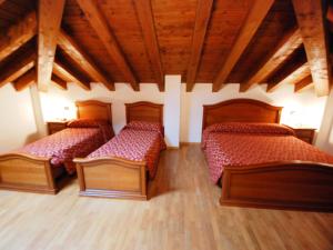 two beds in a room with wooden ceilings at Apartment Albergo Diffuso - Cjasa Fantin by Interhome in Barcis