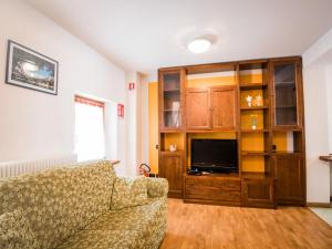 ein Wohnzimmer mit einem Sofa und einem TV in der Unterkunft Apartment Albergo Diffuso - Cjasa Fantin by Interhome in Barcis