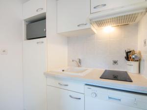 een witte keuken met een wastafel en een aanrecht bij Studio Appartement Aillerie by Interhome in Dinard