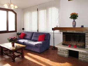 ポルレッツァにあるApartment Nicole by Interhomeのリビングルーム(青いソファ、暖炉付)