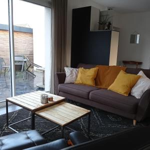 a living room with a couch and a coffee table at Le Salix, petite maison proche de Lille, entre ville et campagne in Wavrin