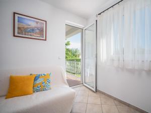 a living room with a white couch and a sliding glass door at Apartment Fiore-1 by Interhome in Gedići +20 photos