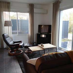 sala de estar con sofá y mesa en Le Salix, petite maison proche de Lille, entre ville et campagne, en Wavrin
