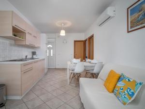a living room with a white couch and a kitchen at Apartment Fiore-1 by Interhome in Gedići