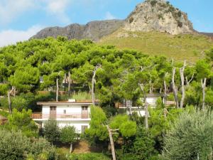 a house in front of a mountain with trees at Apartment Costa di Kair ed Din-3 by Interhome in Sperlonga