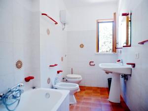 a white bathroom with a toilet and a sink at Apartment Costa di Kair ed Din-3 by Interhome in Sperlonga