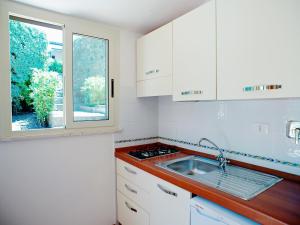 a kitchen with white cabinets and a sink and a window at Apartment Costa di Kair ed Din-3 by Interhome in Sperlonga +18 photos
