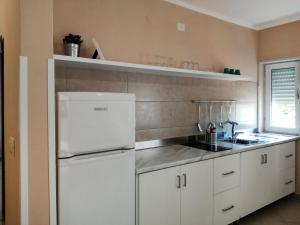 cocina con armarios blancos y nevera blanca en Apartment Laura-1 by Interhome, en Castellammare di Velia