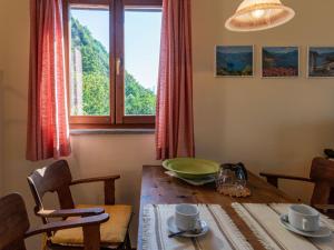 uma sala de jantar com uma mesa e uma janela em Apartment Arte e Cucina-1 by Interhome em Gravedona