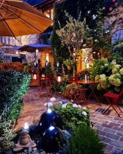 a garden with a table and chairs and plants at La Cour Sainte Catherine demeure de charme in Honfleur