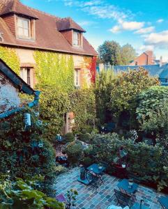 a garden with chairs and plants in front of a house at La Cour Sainte Catherine demeure de charme in Honfleur