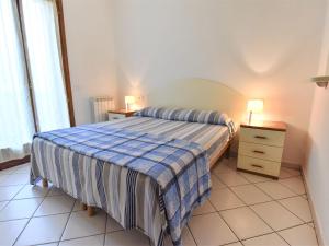 ein Schlafzimmer mit einem Bett, einer Kommode und zwei Lampen in der Unterkunft Apartment Solmare-31 by Interhome in Rosapineta