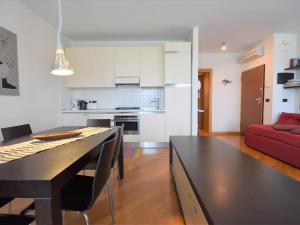 Il comprend une cuisine et un salon avec une table et un canapé rouge. dans l'établissement Apartment Judeca Nova by Interhome, à Venise