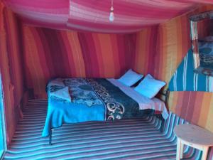 Chegaga Nomad Camp في El Gouera: غرفة نوم بسرير في خيمة