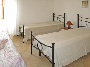 ラ・カレッタにあるHoliday Home La Caletta - TTA100 by Interhomeのベッドルーム1室(ベッド2台、ランプ付きテーブル付)