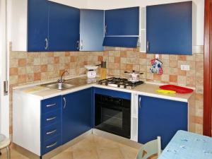a kitchen with blue cabinets and a sink at Holiday Home Lia by Interhome in La Caletta