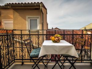 a table with a bowl of fruit on a balcony at Apartment Snježana-3 by Interhome in Karlobag