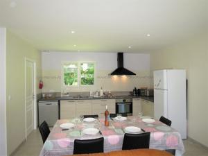 y cocina con mesa, sillas y nevera. en Holiday Home La Casita - CEM110 by Interhome, en Civrac-en-Médoc