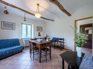 Una sala de estar con una mesa y un sofá azul. en Apartment Cascina Villa - AST231 by Interhome, en Rocca D'Arazzo