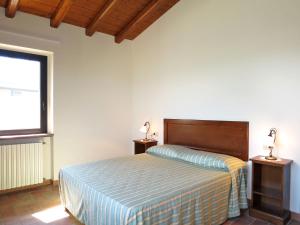 CastanaにあるApartment La Corte Bricca - Bilo C by Interhomeのベッドルーム1室(ベッド1台、テーブルにランプ2つ付)