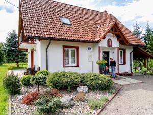 a woman standing outside of a small house at Holiday Home Lgota by Interhome in Witanowice