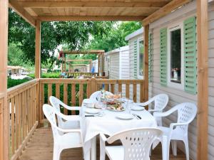 a white table and chairs on a wooden deck at Holiday Home Camping Laguna Village-1 by Interhome in Porto Falconera