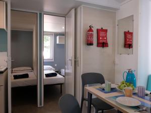 Porto FalconeraにあるHoliday Home Camping Laguna Village-1 by Interhomeのダイニングテーブルと寝室のある部屋
