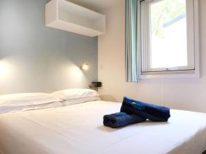 Porto FalconeraにあるHoliday Home Camping Laguna Village-1 by Interhomeの白いベッド(青い袋付) +23枚の写真