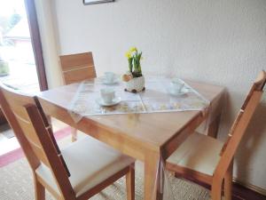 a wooden table with a vase of flowers on it at Apartment Schleichert-1 by Interhome in Barkholt