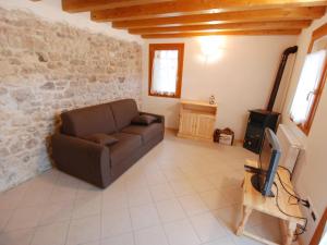 salon z kanapą i telewizorem w obiekcie Holiday Home Albergo Diffuso - Cjasa Paron Cilli by Interhome w mieście Barcis