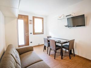 ein Wohnzimmer mit einem Sofa, einem Tisch und Stühlen in der Unterkunft Apartment Albergo Diffuso - Cjasa de Pagnocca-1 by Interhome in Barcis