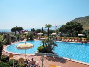 a pool at a resort with people sitting around it at Apartment Costa di Kair ed Din-6 by Interhome in Sperlonga