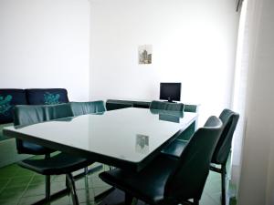 a dining room table with chairs and a laptop on it at Apartment Costa di Kair ed Din-6 by Interhome in Sperlonga