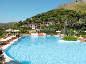 a large swimming pool with a mountain in the background at Apartment Costa di Kair ed Din-6 by Interhome in Sperlonga