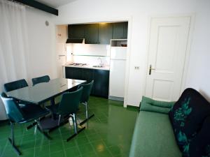 a kitchen with a table and chairs and a couch at Apartment Costa di Kair ed Din-6 by Interhome in Sperlonga