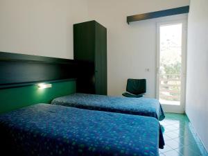 a hotel room with two beds and a window at Apartment Costa di Kair ed Din-6 by Interhome in Sperlonga