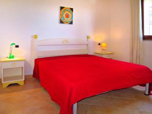ポルト・ポッツォにあるApartment I Mirti di Porto Pozzo - PPZ120 by Interhomeのベッドルーム1室(赤いベッド1台、ナイトスタンド2台付)